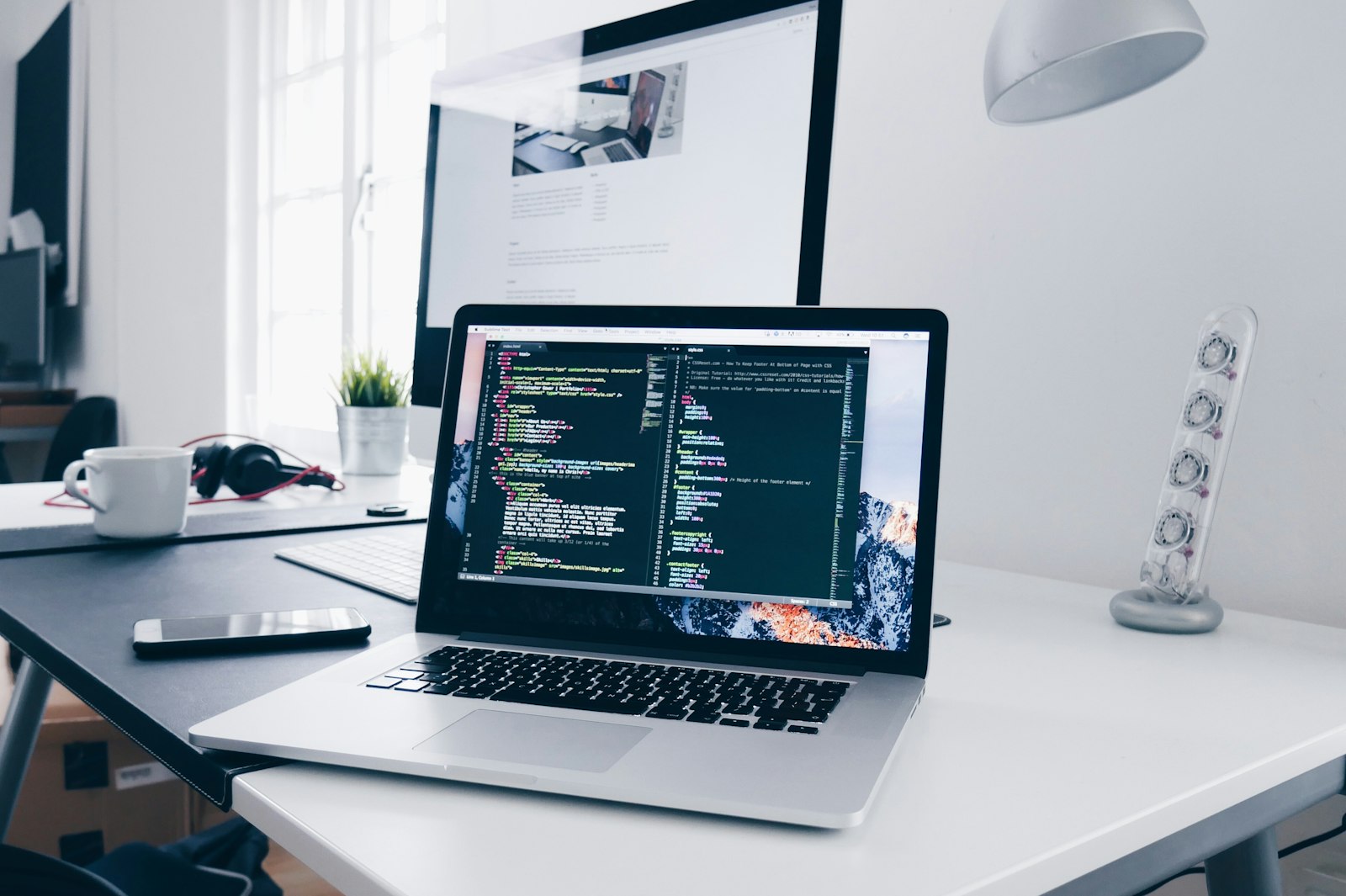 Laptop con un editor de código en un escritorio de desarrollo